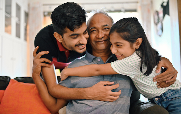 Grandchildren embracing their senior grandfather lovingly